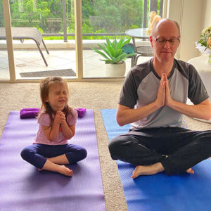 Young girl and man doing yoga